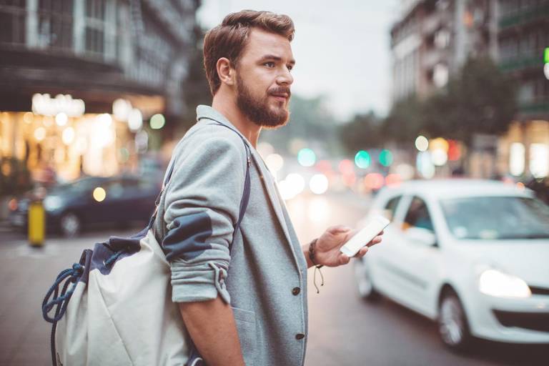 Man with Smartphone in City Traffic