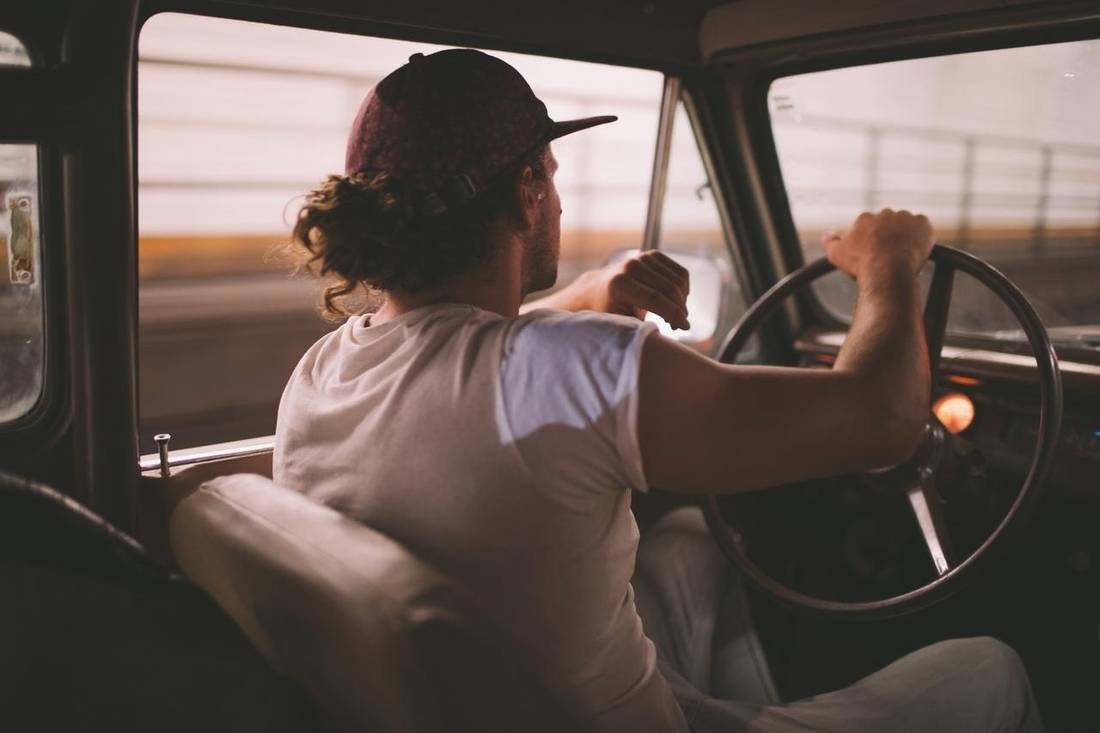 Man sitting behind of steering wheel in his car