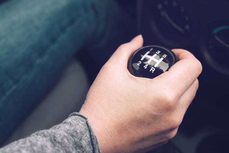 Hand am schaltknauf des autos der fahrer schaltet die geschwindigkeit im  auto hand am schalthebel